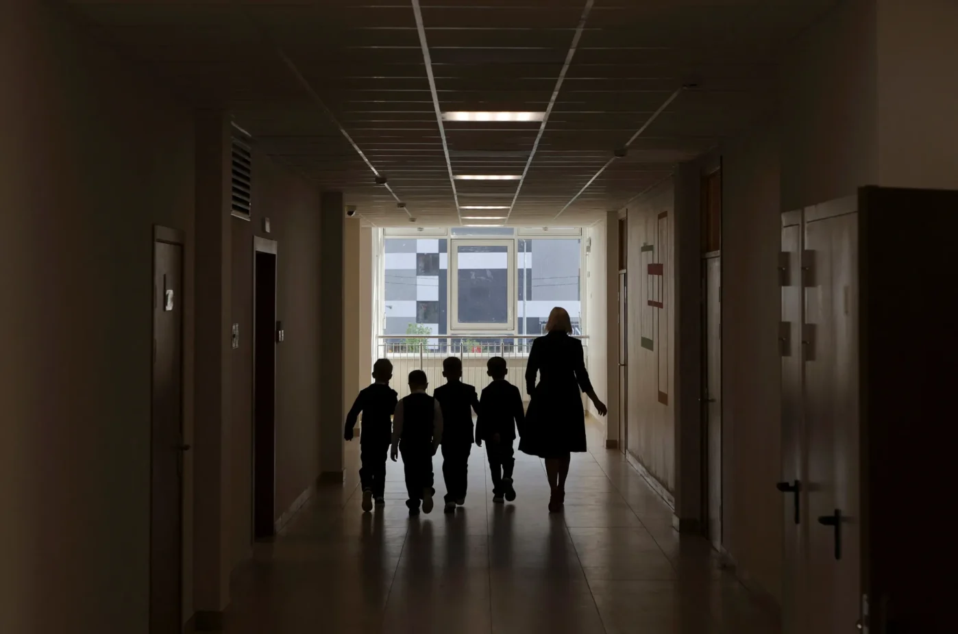 Учитель и&nbsp;ученики идут по&nbsp;коридору новой школы в&nbsp;День знаний в&nbsp;Санкт-Петербурге