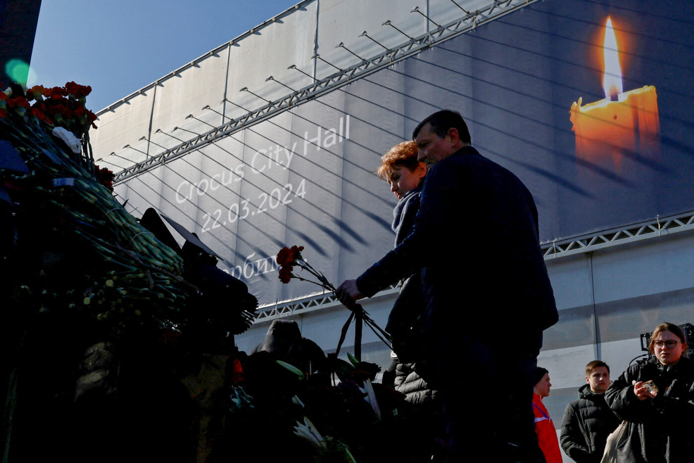 Люди возлагают цветы к&nbsp;открытому мемориалу жертвам теракта в&nbsp;«Крокус Сити Холл»